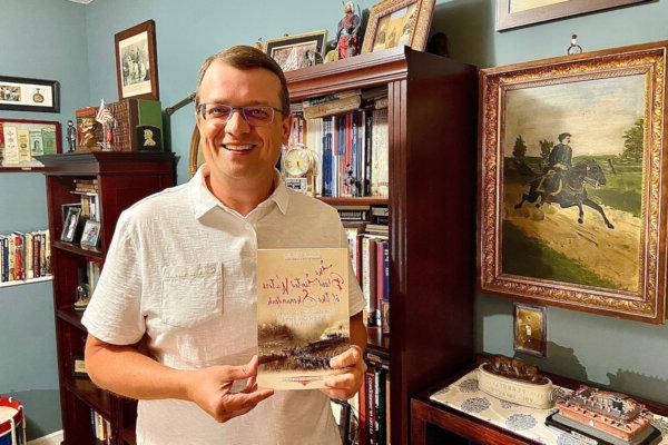 Jonathan Noyalas holds a copy of his new book, "The Blood-Tinted Waters of the Shenandoah."